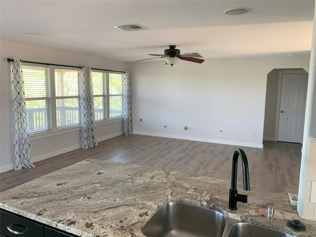 4102 Glendale Ln, Lago Vista, TX 78645 - kitchen with a ceiling fan, wood finished floors, and light stone counters
