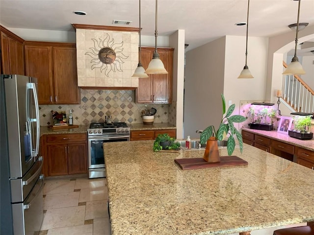 1813 Country Squire Dr, Cedar Park, TX 78613 - kitchen with appliances with stainless steel finishes, decorative backsplash, light stone countertops, brown cabinetry, and a kitchen island with sink