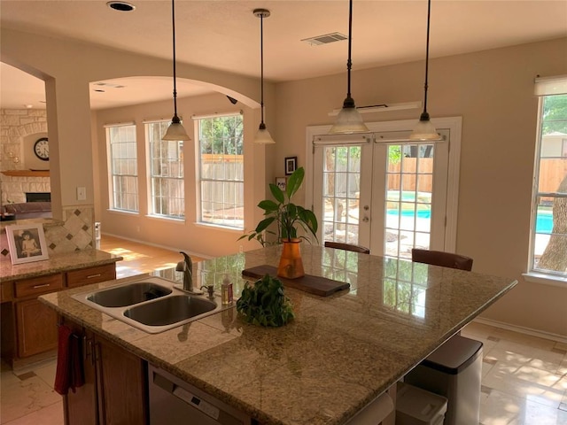 1813 Country Squire Dr, Cedar Park, TX 78613 - kitchen featuring dishwasher, a sink, an island with sink, brown cabinets, and baseboards