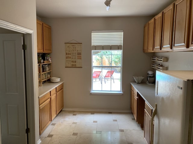 1813 Country Squire Dr, Cedar Park, TX 78613 - kitchen featuring freestanding refrigerator, light countertops, baseboards, and brown cabinets
