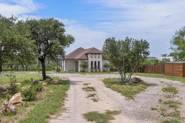 25036 River Rd, Spicewood, TX 78669 - view of front of house featuring stucco siding and curved driveway