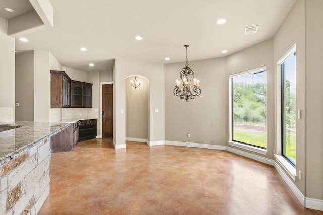 25036 River Rd, Spicewood, TX 78669 - kitchen featuring finished concrete floors, plenty of natural light, a chandelier, recessed lighting, and dark brown cabinetry