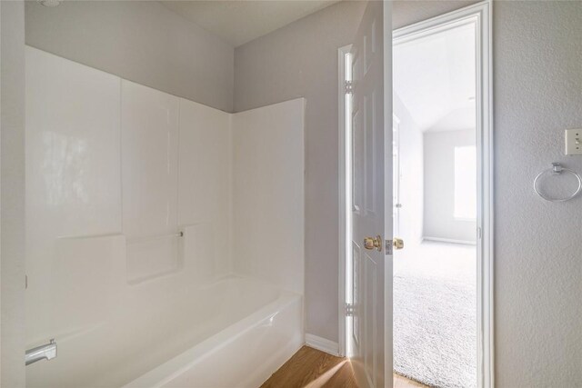 2509 Riddle Rd, Austin, TX 78748 - full bathroom featuring wood finished floors, shower / washtub combination, and baseboards