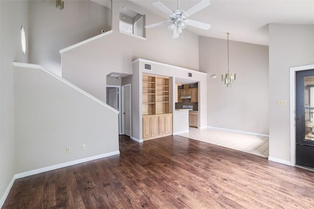 2509 Riddle Rd, Austin, TX 78748 - unfurnished living room featuring high vaulted ceiling, a chandelier, wood finished floors, baseboards, and ceiling fan
