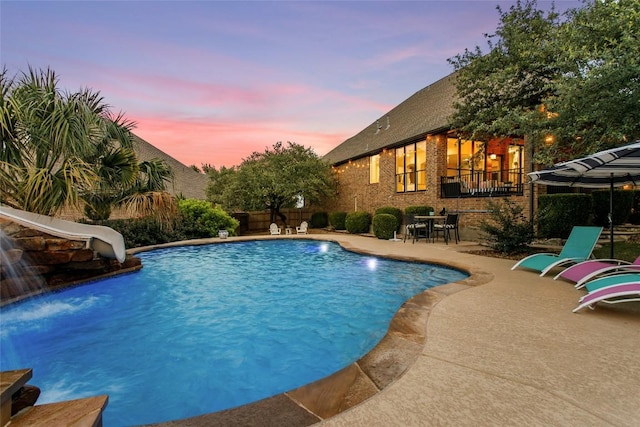 405 Mirafield Ln, Austin, TX 78737 - pool at dusk featuring a water slide, an outdoor pool, and a patio area