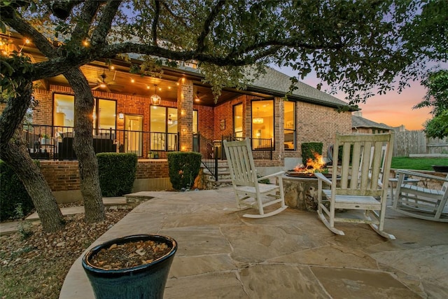 405 Mirafield Ln, Austin, TX 78737 - back of property at dusk featuring a fire pit, brick siding, and covered porch