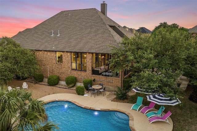 405 Mirafield Ln, Austin, TX 78737 - rear view of property with a patio area, brick siding, a chimney, a shingled roof, and an outdoor pool