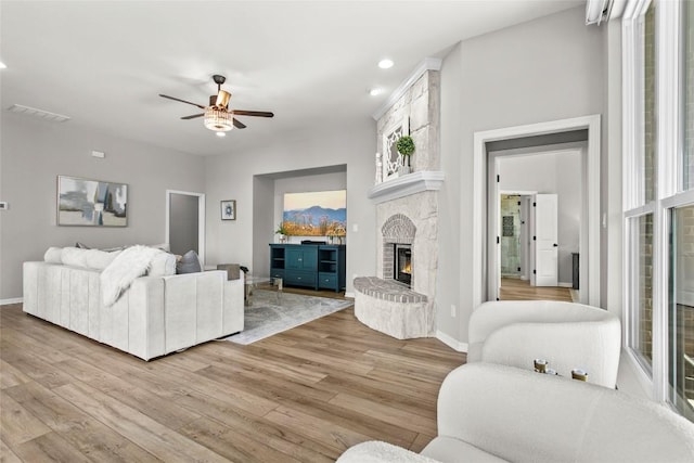 405 Mirafield Ln, Austin, TX 78737 - living room featuring light wood finished floors, a ceiling fan, a glass covered fireplace, and recessed lighting