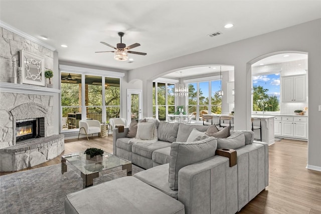405 Mirafield Ln, Austin, TX 78737 - living room featuring ceiling fan, light wood-style floors, a stone fireplace, recessed lighting, and a chandelier