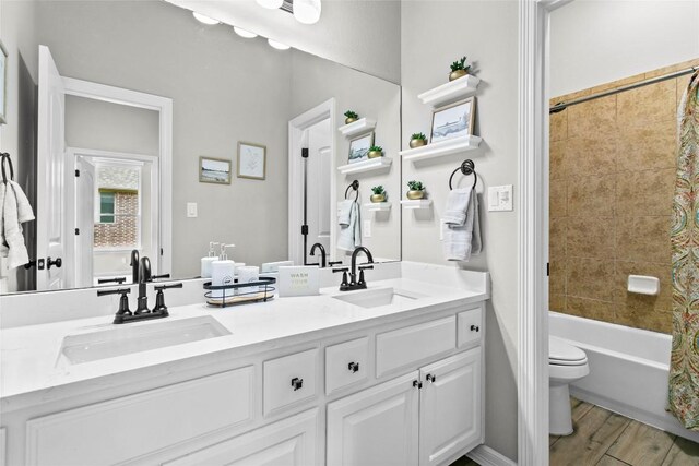 405 Mirafield Ln, Austin, TX 78737 - full bathroom with double vanity, toilet, shower / tub combo with curtain, and wood finished floors