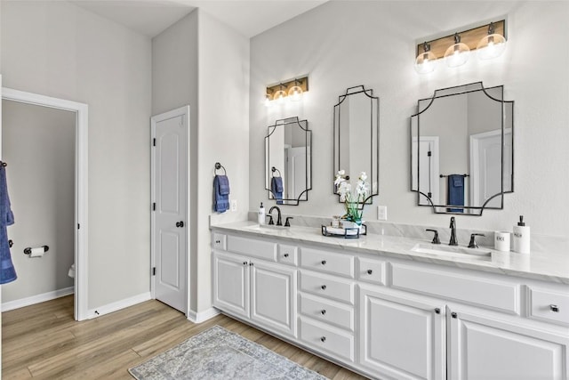 405 Mirafield Ln, Austin, TX 78737 - full bathroom featuring double vanity, wood finished floors, toilet, and baseboards