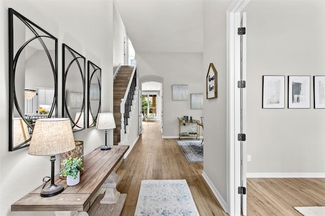 405 Mirafield Ln, Austin, TX 78737 - corridor featuring arched walkways, wood-type flooring, baseboards, a high ceiling, and stairs