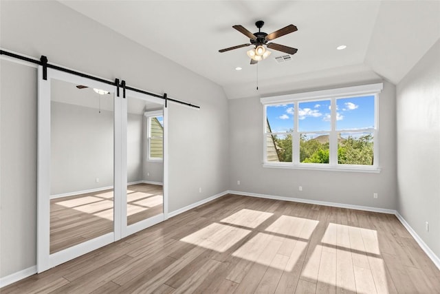 405 Mirafield Ln, Austin, TX 78737 - unfurnished bedroom with a barn door, light wood-style floors, baseboards, and recessed lighting