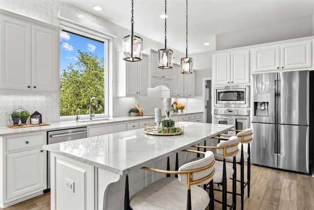 405 Mirafield Ln, Austin, TX 78737 - kitchen featuring appliances with stainless steel finishes, a sink, a center island, white cabinets, and recessed lighting
