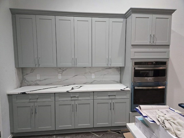 1525 Waco St, Gonzales, TX 78629 - kitchen featuring gray cabinets, double oven, light countertops, and decorative backsplash