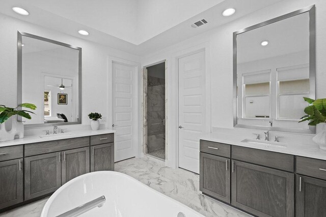 5324 Agatha Cir, Austin, TX 78724 - bathroom featuring marble finish floors, recessed lighting, a freestanding tub, and two vanities