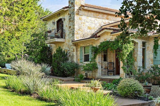 1607 The High Rd, Austin, TX 78746 - view of front of house featuring a balcony, stone siding, and a chimney