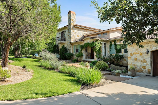 1607 The High Rd, Austin, TX 78746 - view of front of house with stone siding, a front lawn, stucco siding, a chimney, and a tile roof