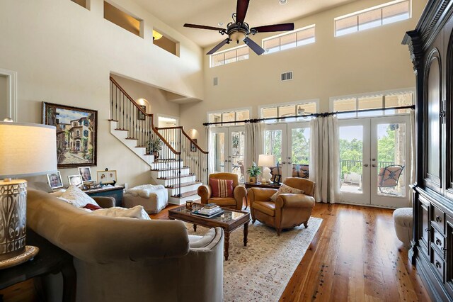 1607 The High Rd, Austin, TX 78746 - living room featuring french doors, stairway, ceiling fan, wood finished floors, and a high ceiling