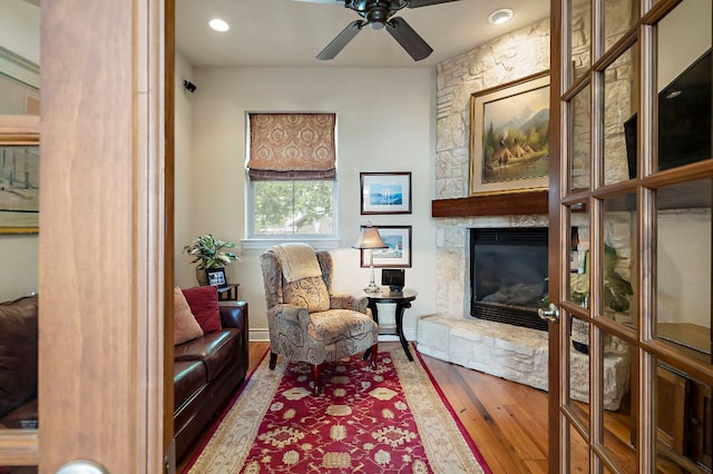 1607 The High Rd, Austin, TX 78746 - sitting room featuring a stone fireplace, ceiling fan, hardwood / wood-style flooring, and recessed lighting