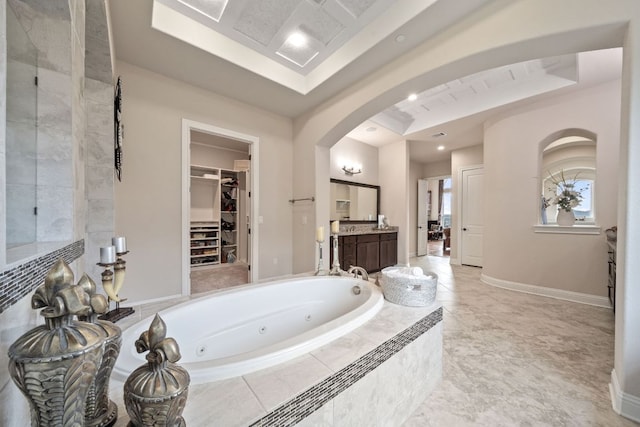 2329 Sandorna Ct, Leander, TX 78641 - full bath with vanity, a jetted tub, a raised ceiling, a spacious closet, and recessed lighting