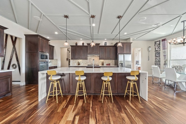 2329 Sandorna Ct, Leander, TX 78641 - kitchen with appliances with stainless steel finishes, dark wood finished floors, tasteful backsplash, and recessed lighting