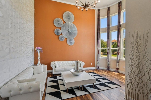 2329 Sandorna Ct, Leander, TX 78641 - living room featuring a chandelier, wood finished floors, an accent wall, and a high ceiling