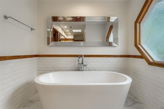 213 Hurst Creek Rd, Austin, TX 78734 - full bath with marble look tiles, tile walls, a freestanding tub, and wainscoting