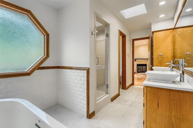 213 Hurst Creek Rd, Austin, TX 78734 - full bath with a skylight, a shower stall, a bath, vanity, and tile patterned flooring