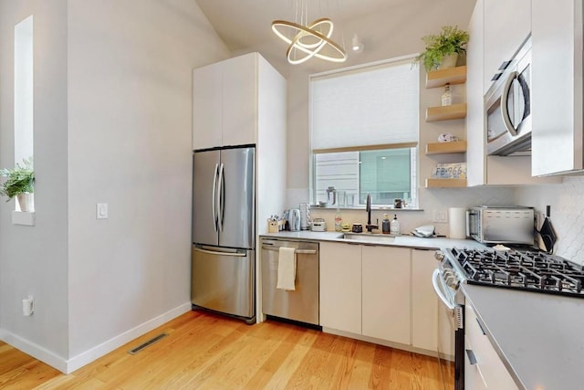 913 Duncan Ln Unit 103, Austin, TX 78705 - kitchen with stainless steel appliances, a sink, light wood finished floors, light countertops, and open shelves