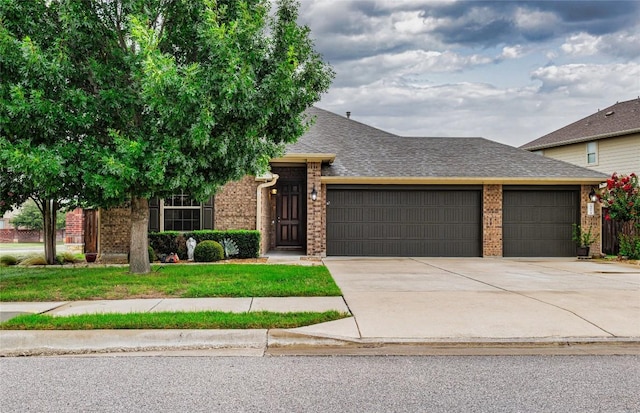 1501 Daylily Loop, Georgetown, TX 78626 - view of front of house with a garage, brick siding, a shingled roof, and driveway