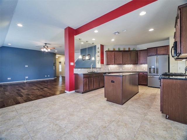 1501 Daylily Loop, Georgetown, TX 78626 - kitchen featuring stainless steel fridge with ice dispenser, a center island, a ceiling fan, open floor plan, and black microwave