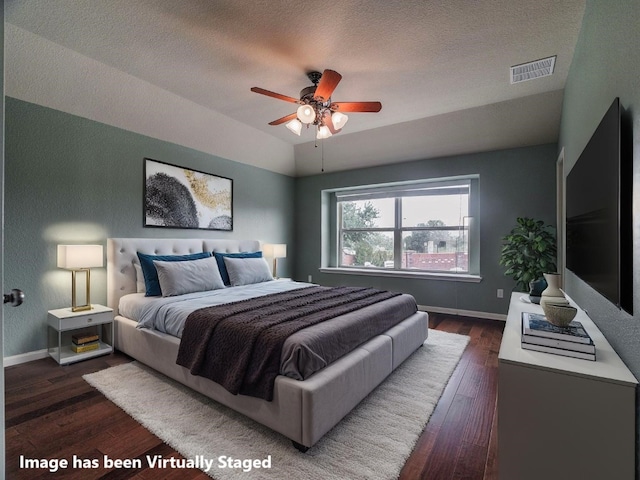 1501 Daylily Loop, Georgetown, TX 78626 - bedroom with dark wood-style floors, a textured ceiling, vaulted ceiling, a ceiling fan, and a textured wall