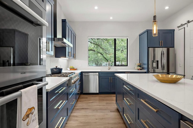 2312 Pruett St, Austin, TX 78703 - kitchen featuring appliances with stainless steel finishes, blue cabinetry, a sink, a barn door, and recessed lighting