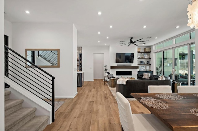 2312 Pruett St, Austin, TX 78703 - dining space with light wood-style floors, a ceiling fan, stairs, recessed lighting, and a fireplace