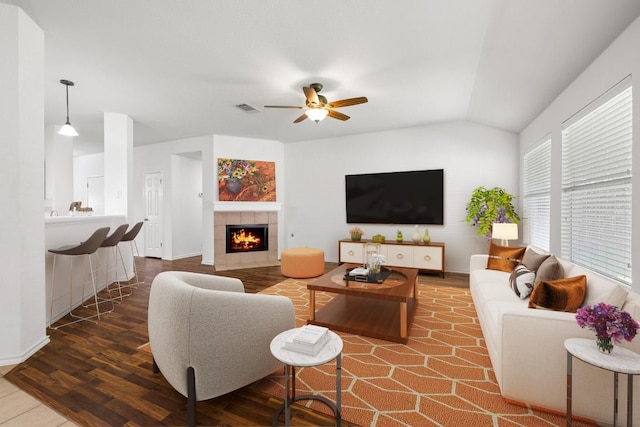 2803 Glenwood Trl, Cedar Park, TX 78613 - living room featuring wood finished floors, a ceiling fan, a tiled fireplace, lofted ceiling, and baseboards