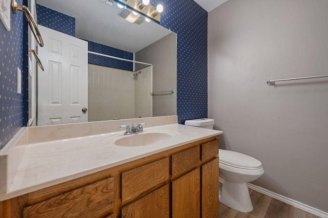 11814 Barrington Way, Austin, TX 78759 - bathroom featuring wallpapered walls, toilet, wood finished floors, a tile shower, and vanity