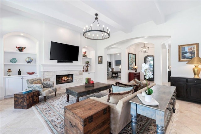 213 Black Wolf Run, Austin, TX 78738 - living room featuring arched walkways, built in shelves, beam ceiling, a chandelier, and a fireplace
