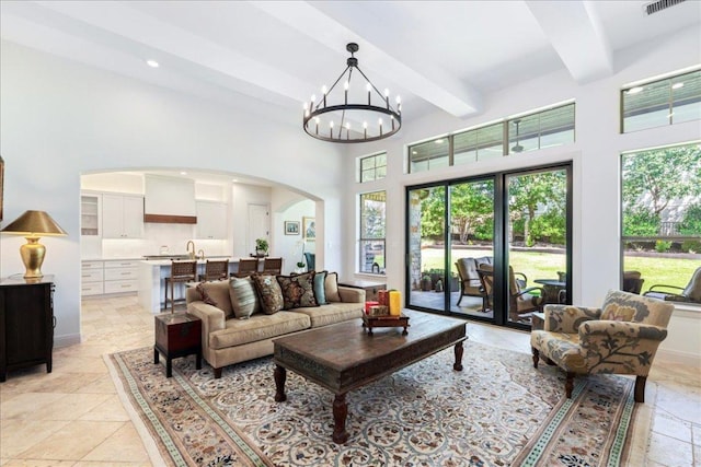 213 Black Wolf Run, Austin, TX 78738 - living area with arched walkways, beam ceiling, a towering ceiling, a chandelier, and recessed lighting