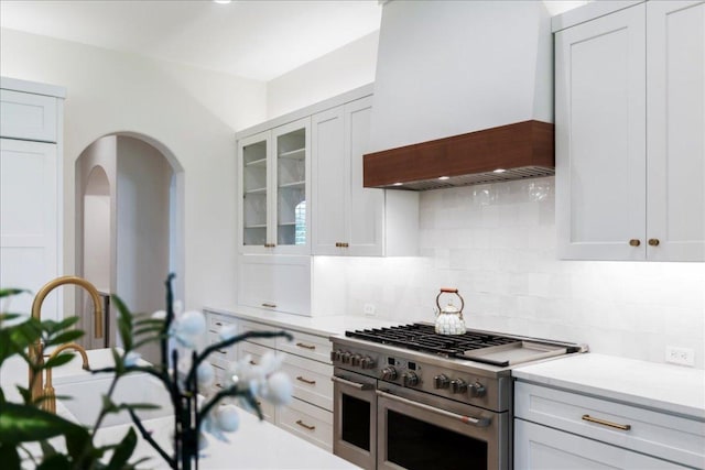 213 Black Wolf Run, Austin, TX 78738 - kitchen featuring stainless steel stove, premium range hood, backsplash, and light countertops