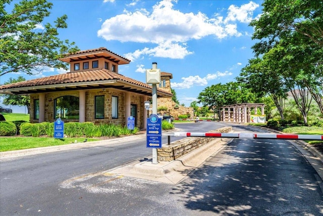 213 Black Wolf Run, Austin, TX 78738 - view of asphalt road featuring curbs and a gated entry
