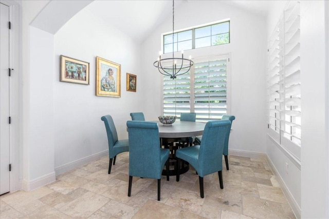 213 Black Wolf Run, Austin, TX 78738 - dining space with stone tile floors, a chandelier, baseboards, arched walkways, and high vaulted ceiling