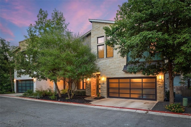 2807 Del Curto Rd Unit G, Austin, TX 78704 - modern home with stone siding, a garage, and driveway