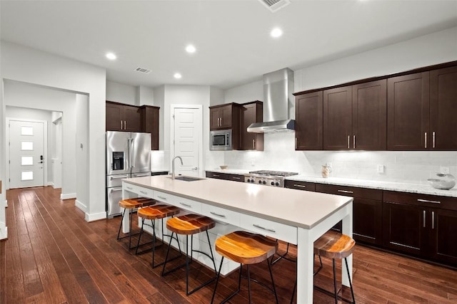 2807 Del Curto Rd Unit G, Austin, TX 78704 - kitchen featuring wall chimney range hood, stainless steel appliances, a sink, a kitchen breakfast bar, and light countertops