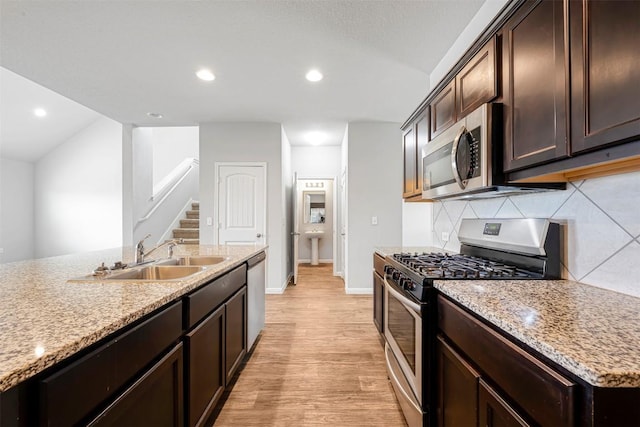 10820 Gonzales Ranger Pass, Austin, TX 78754 - kitchen featuring stainless steel appliances, a sink, decorative backsplash, light wood-type flooring, and dark brown cabinetry