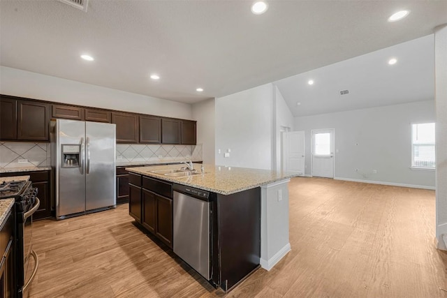 10820 Gonzales Ranger Pass, Austin, TX 78754 - kitchen featuring appliances with stainless steel finishes, a sink, dark brown cabinetry, light wood-type flooring, and backsplash