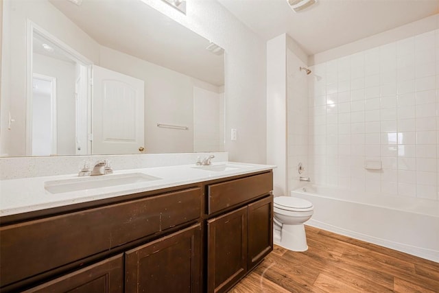 10820 Gonzales Ranger Pass, Austin, TX 78754 - full bath with double vanity, toilet, wood finished floors, and bathtub / shower combination
