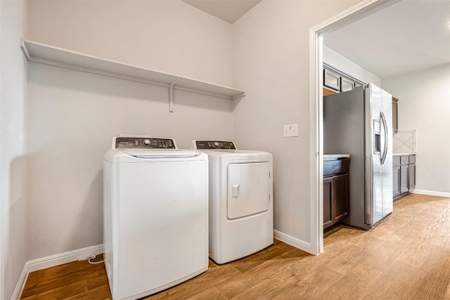 10820 Gonzales Ranger Pass, Austin, TX 78754 - laundry room featuring washing machine and dryer, light wood-style flooring, and baseboards