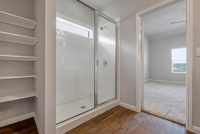 10820 Gonzales Ranger Pass, Austin, TX 78754 - bathroom featuring tiled shower, wood finished floors, and baseboards