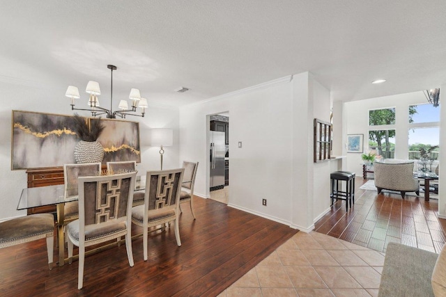 111 Hiver Cir, Kyle, TX 78640 - dining area with a chandelier, wood finished floors, recessed lighting, and ornamental molding